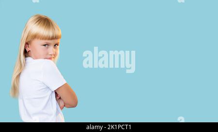 Frech Kind. Verhalten von Kindern. Bildungsproblem. Porträt von beleidigt unzufrieden blonde kleine Mädchen in weißem T-Shirt Blick zurück mit gefalteten Armen i Stockfoto