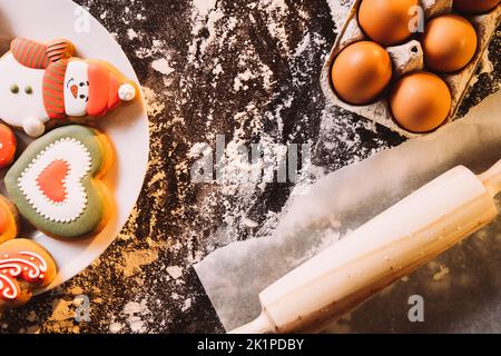 Schöner kulinarischer Hintergrund. Alles gute zum Valentinstag. Festlich dekorierte Bäckerei. Lebkuchen bunte Puderkekse Rollen Stift Eier Tablett auf Mehl gepudert Stockfoto