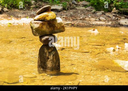 Eine Nahaufnahme von balancierten Felsen in einem schmutzigen Wasser Stockfoto