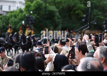 Mitglieder der Öffentlichkeit halten ihre Kameratelefone, während Mitglieder der Royal Horse Artillery Wache während der feierlichen Prozession für das Staatsfuneral von Königin Elizabeth II. Halten, die in Westminster Abbey, London, stattfindet, während es Wellington Arch verlässt. Bilddatum: Montag, 19. September 2022. Stockfoto