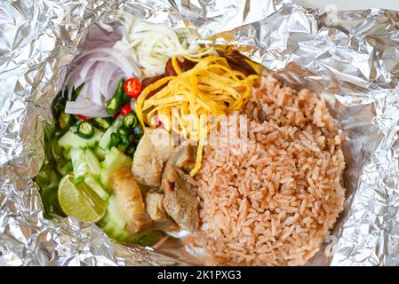 Thai-Lebensmittel auf Box mit Aluminiumfolie Lebensmittelverpackung Essen zum Mitnehmen - Reis gemischt mit Garnelenpaste gebratener Reis auf Box, Reis gewürzt mit Garnelenpaste Rezept, r Stockfoto