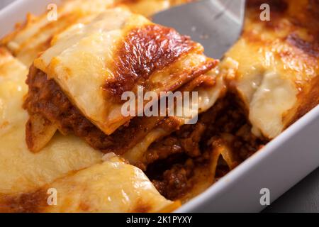 Frische Lasagne mit Fleisch- und Tomatensauce, die im Ofen in einer Keramikschale gebacken wurde. Stockfoto