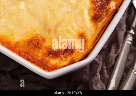 Frische Lasagne mit Fleisch- und Tomatensauce, die im Ofen in einer Keramikschale gebacken wurde. Stockfoto