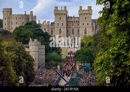 Die Königin kehrt zum letzten Mal nach dem Staatsfuneral in der Westminster Abbey in ihr geliebtes Haus Windsor Castle zurück. Riesige Menschenmengen säumten den langen Spaziergang, um sich von Ihrer Majestät zu verabschieden, als der staatliche Leichenwagen langsam an ihnen vorbeiging. Die Prozession betrat das Schlossgelände über den langen Spaziergang. Stockfoto