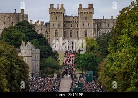 Die Königin kehrt zum letzten Mal nach dem Staatsfuneral in der Westminster Abbey in ihr geliebtes Haus Windsor Castle zurück. Riesige Menschenmengen säumten den langen Spaziergang, um sich von Ihrer Majestät zu verabschieden, als der staatliche Leichenwagen langsam an ihnen vorbeiging. Die Prozession betrat das Schlossgelände über den langen Spaziergang. Stockfoto