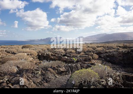 Landschaft am unterirdischen Eingang zu den vulkanischen Höhlen 'Cueva de los Verdes', Lanzarote, Spanien. Im Hintergrund der Atlantik und das Schlepptau Stockfoto