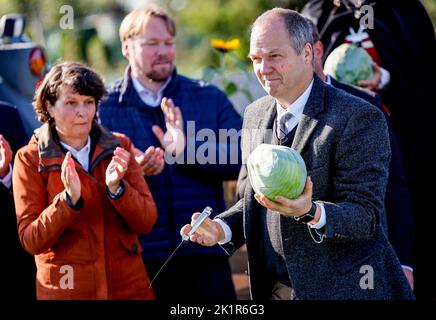 20. September 2022, Schleswig-Holstein, Eesch-Elpersbüttel: Werner Schwarz (CDU), Schleswig-Holsteins Landwirtschaftsminister, überreicht bei den Dithmarsch Kohltagen einen von ihm geschnittenen Kohlkopf. Der erste Kohl wurde von Ute Borwieck-Dethlefs (CDU, l), Bezirksvorsitzender des Landkreises Dithmarschen, geschnitten. Schwarz ist Ehrengast. Foto: Axel Heimken/dpa Stockfoto