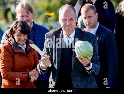 20. September 2022, Schleswig-Holstein, Eesch-Elpersbüttel: Werner Schwarz (CDU), Schleswig-Holsteins Landwirtschaftsminister, überreicht bei den Dithmarsch Kohltagen einen von ihm geschnittenen Kohlkopf. Der erste Kohl wurde von Ute Borwieck-Dethlefs (CDU, l), Bezirksvorsitzender des Landkreises Dithmarschen, geschnitten. Schwarz ist Ehrengast. Foto: Axel Heimken/dpa Stockfoto