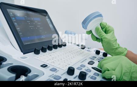 Sonographie. Medizinischer Ultraschallwandler in der Hand des Arztes, Nahaufnahme in der Nähe des Ultraschallgeräts in der medizinischen Klinik Stockfoto