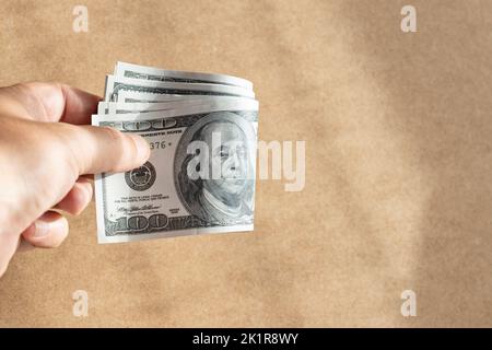 Hand mit einer Gruppe gefalteter US-Dollar-Banknoten. Speicherplatz kopieren Stockfoto