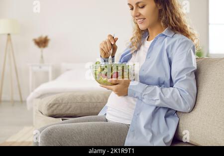 Glückliche junge Frau essen gesunden vegetarischen Salat Stockfoto