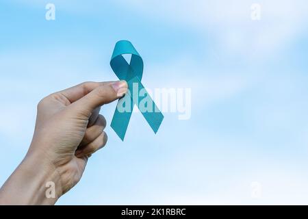 November Prostatakrebs Bewusstsein Monat, Mann hält Licht Blue Ribbon für die Unterstützung von Menschen leben und Krankheit. Gesundheitswesen, Internationale Männer, Fathe Stockfoto