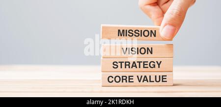 Business man Hand hält Holzblock mit MISSION, VISION, STRATEGIE und KERNWERTTEXT Stockfoto