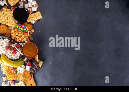 S'mores Home Party Essen und Zutaten. Smores Buffet Hintergrund mit verschiedenen marmelow, Cracker, Schokolade, Obst, Schokolade, Toppings, Saucen. Stockfoto