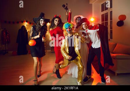 Portrait von multirassischen erwachsenen Freunden in gruseligen Kostümen, die Spaß auf der Halloween Party haben. Stockfoto
