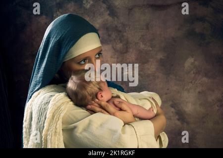 Live-Nachstellung Weihnachtskrippe der echten Mutter eines 8 Tage alten Jungen, der die Jungfrau Maria und das Jesuskind spielt Stockfoto