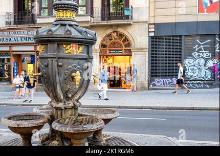 La Rambla, Eine Nahaufnahme eines alten Trinkwasserbrunnens in Schwarz und Gold. Stockfoto