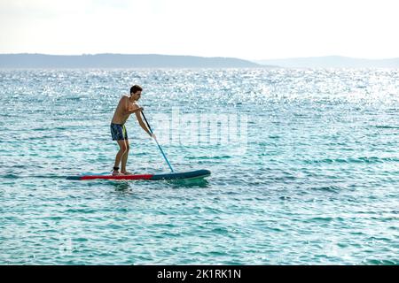 Junge segelt auf dem Boot in der Adria gegenüber der Insel Brac in Kroatien Stockfoto