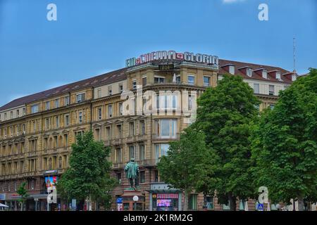 Das Bild zeigt ein großes altes Eckhaus am Stuttgarter Schlossplatz mit farbenfroher Werbung für das Kino im Gebäude auf dem Dach Stockfoto