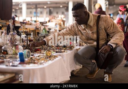 Afroamerikanischer Mann wählt Antiquitäten auf dem Flohmarkt Stockfoto