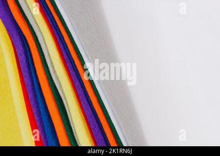 Hintergrund mit Filzstruktur. Mehrere farbige Filzstofflaken auf weißem Hintergrund. Verschiedene Farben Filz Stofflaken, Patchwork, Nähen DIY Handwerk Stockfoto