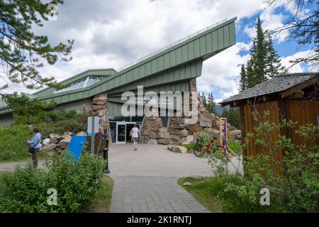 Lake Louise, Alberta, Kanada - 9. Juli 2022: Touristen gehen in das Gebäude des Banff National Park Visitors Center Stockfoto