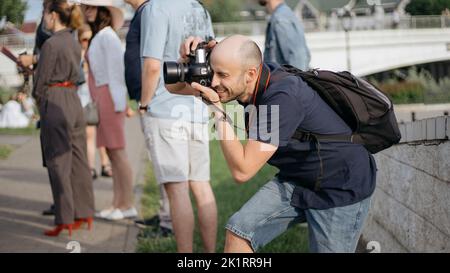 Junger Mann mit Kamera, der während eines Ausflugs ein Foto gemacht hat. Stockfoto