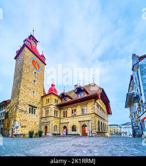 LUZERN, SCHWEIZ - 30. MÄRZ 2022: Mittelalterliches Steinhaus mit Uhrenturm am Kornmarkt, am 30. März in Luzern, Schweiz Stockfoto