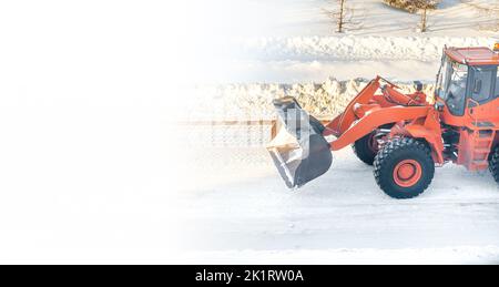 Großer orangefarbener Traktor entfernt Schnee von der Straße und räumt den Bürgersteig Stockfoto