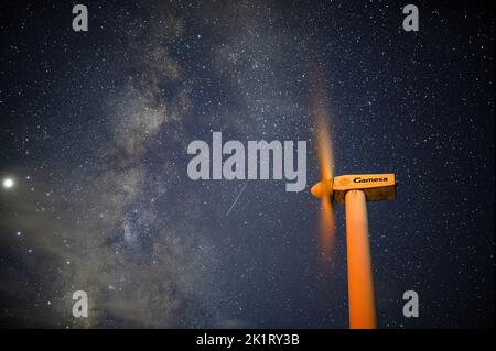 Ein faszinierender Blick auf eine sternenklare Nacht mit einer funktionierenden Windturbine auf dem Gipfel des Xianning Jiugong Berges Stockfoto