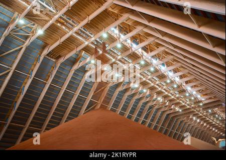 Gießen von roten Phosphatdüngern auf Stapel im Lagerhaus Stockfoto