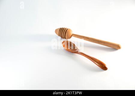 Holzlöffel und Honigtaucher auf isoliertem weißem Hintergrund Stockfoto