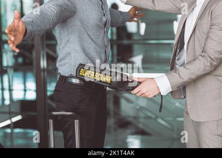 flughafen-Sicherheitskontrolle Offizier mit Metallwaffe Scanner-Detektor überprüfen jeden Passagier Stockfoto