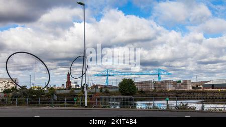 Ein Blick auf die Temenos Kunst Struktur von Anish Kapoor mit dem Uhrturm und die Schwebefähre in Middlesbrough Hintergrund Stockfoto