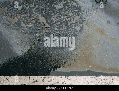 Benzin verschüttet auf Asphalt in einem Parkplatz als Textur oder Hintergrund Stockfoto