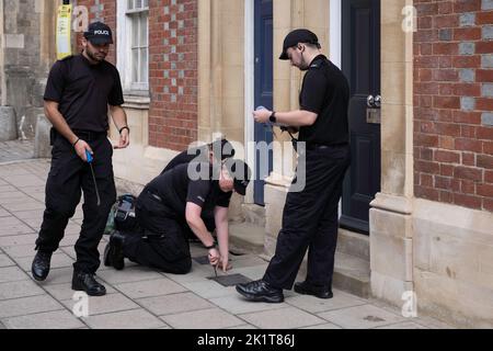 Polizeibeamte überprüfen Schächte in einer Straße in der Nähe von Windsor Castle vor der Beerdigung von Königin Elizabeth wegen massiver Sicherheitsoperation Stockfoto