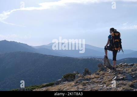 Eine weibliche Reisende mit Rucksack bewundern Berge Stockfoto