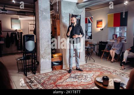 Junger Geschäftsmann mit Mikrofon bei einer öffentlichen Sprechausbildung. Stockfoto
