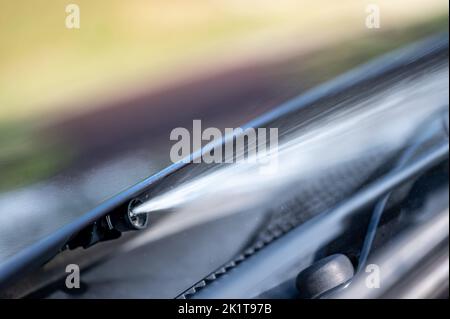 Scheibenwaschdüse unter der Motorhaube, mit der Flüssigkeit zum Reinigen von Glas auf ein Fahrzeug gesprüht wird. Stockfoto