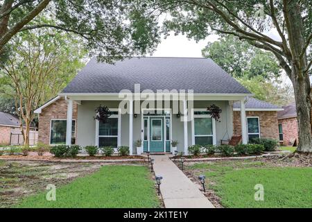 Eine Vorderansicht eines akadischen renovierten Hauses mit Säulen, Gehwegen und einer farbenfrohen Eingangstür, die kürzlich mit dem sich verändernden Immobilienmarkt gekauft wurde Stockfoto