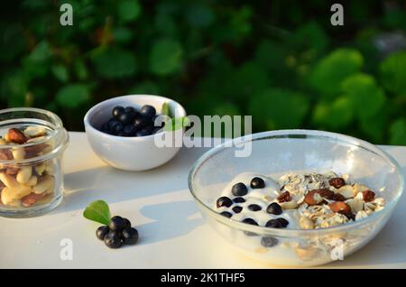 Frühstück mit Müsli, acai-Beere Smoothie, Früchte auf weißem Hintergrund. Gesundes Lebensmittelkonzept. Flach liegend, Draufsicht, Nahaufnahme Stockfoto