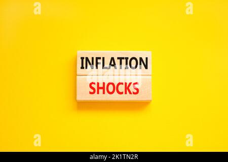 Symbol für Inflationsschocks. Konzept Worte Inflation Schocks auf Holzblöcke. Schöne gelbe Tabelle gelben Hintergrund. Die Inflation der Unternehmen erschüttert das Konzept. Stockfoto