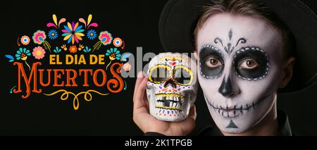 Junger Mann mit gemaltem Gesicht und Zuckerschädel für Mexikos Tag der Toten (El Dia de Muertos) auf dunklem Hintergrund Stockfoto