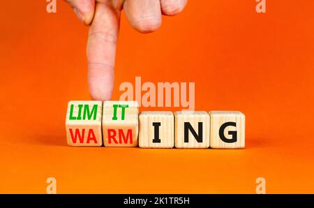 Symbol für Begrenzung der globalen Erwärmung. Konzept Worte Begrenzung und Erwärmung auf Holzwürfel. Geschäftsmann Hand. Schöne orange Tisch orange Hintergrund. Bus Stockfoto