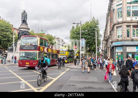 Fußgänger, die eine Straße mit einer Fußgängerüberführung im Stadtzentrum von Dublin, Irland, überqueren. Stockfoto