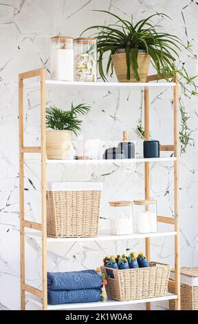 Eine vertikale Aufnahme eines schönen modernen Badezimmerregals mit minimalistischen Holzbehältern und Einrichtungsgegenständen Stockfoto
