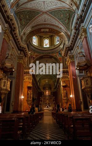 Das Innere der Basilika und des Klosters von San Francisco in Salta mit Menschen, die auf Kirchenbänken sitzen Stockfoto