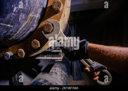 Arbeiter, der Wasserleitung im technischen Tunnel installiert, Nahaufnahme Stockfoto