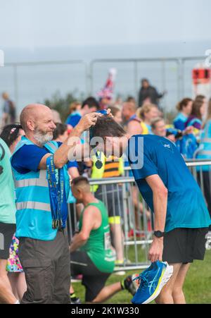 Die Teilnehmer erhielten ihre Medaillen am Ende des Great North Run Halbmarathons 2022 Stockfoto