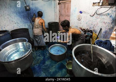 07.12.2011, Mumbai, Maharashtra, Indien, Asien - Arbeiter färben Stoffe in einem Metallfass in einer Werkstatt im Slum Dharavi in Mumbai. Stockfoto